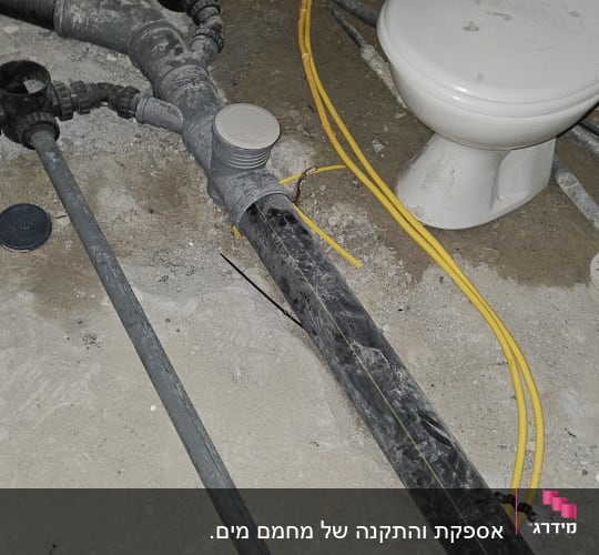 צינורות פלסטיק שחורים וצהובים על רצפת בטון
